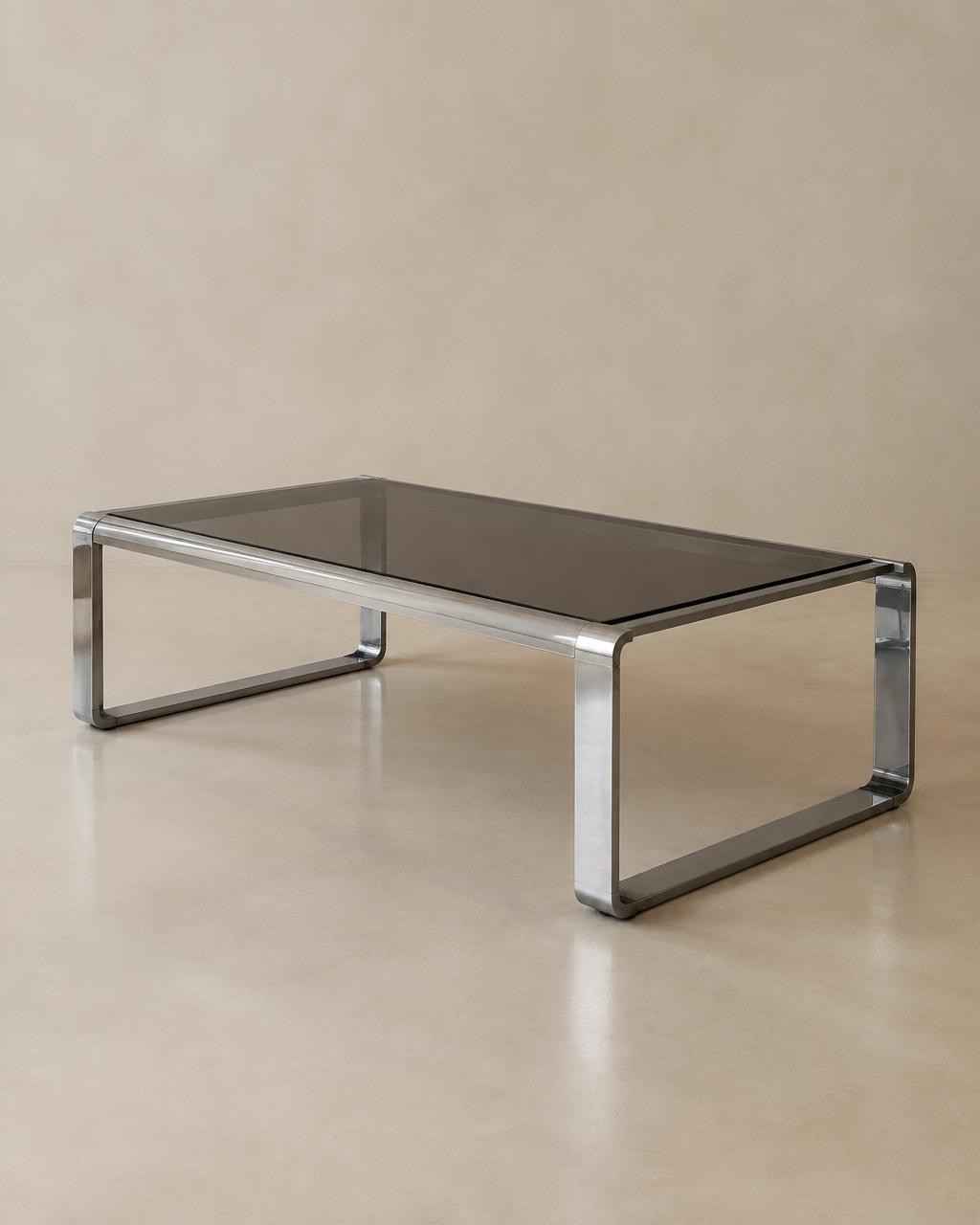 Low smoked glass coffee table with continuous chrome frame