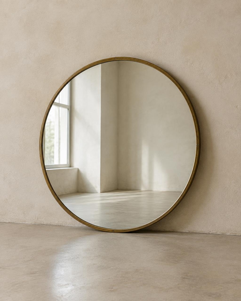 Round 1960s mirror with a slender aged brass frame