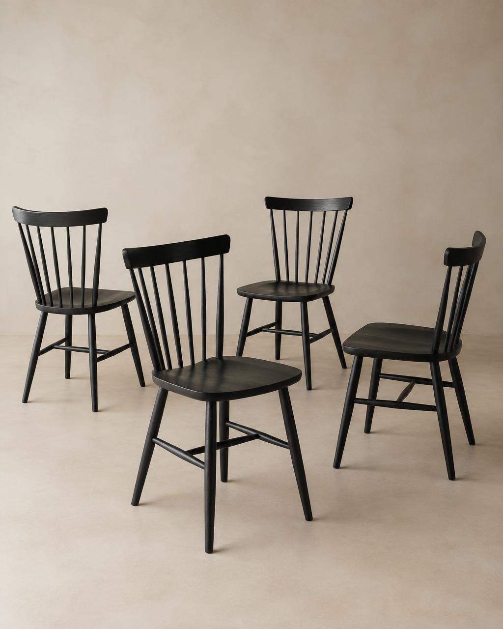 Set of four black timber spindle-back dining chairs